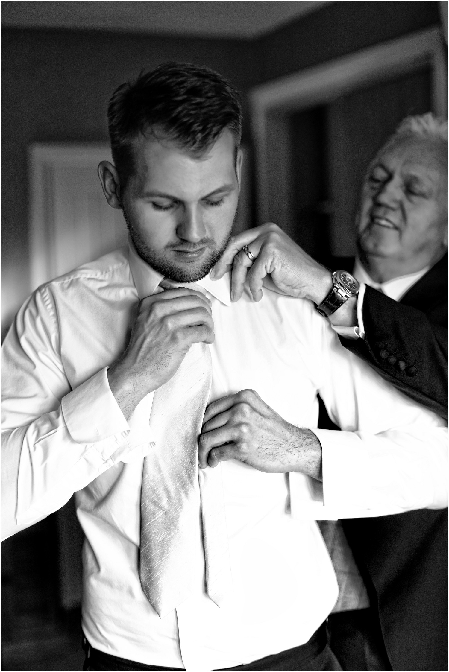 groom putting on tie